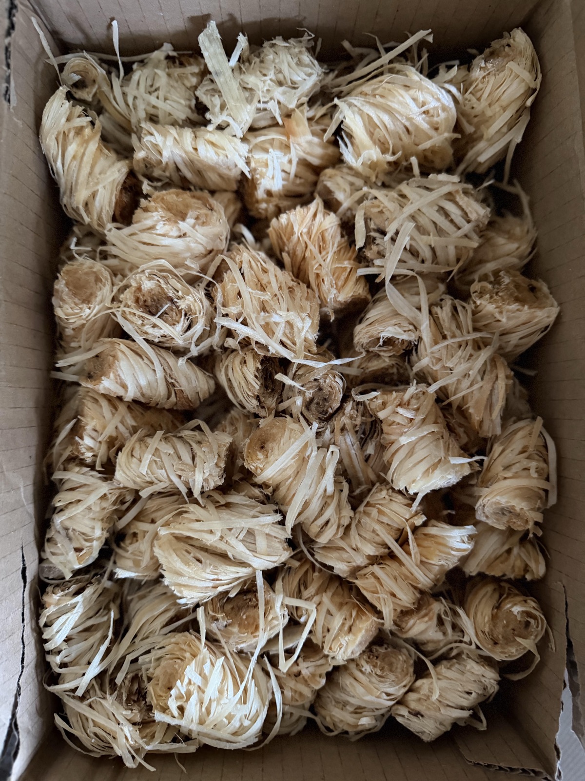 A box full of natural wood-wool firelighters